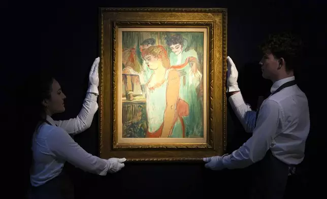 Art handlers display 'La femme tatouee' by Henri De Toulouse-Lautrec at Christie's auction rooms, the painting estimated at 2.5-3.5 million UK pounds will be for auction in the 20th/21st Century London Evening Sale at Christie's in London, Thursday, Oct. 3, 2024. (AP Photo/Kirsty Wigglesworth)