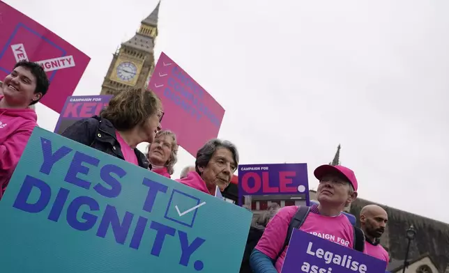 A small demonstration by people advocating assisted dying hold a protest outside the Hoses of Parliament as a bill to legalise assisted dying is to be put before lawmakers in London, England, Wednesday, Oct. 16, 2024. (AP Photo/Alberto Pezzali)