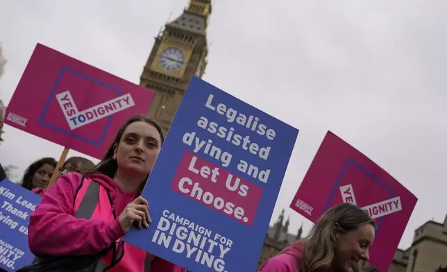 A small demonstration by people advocating assisted dying hold a protest outside the Hoses of Parliament as a bill to legalise assisted dying is to be put before lawmakers in London, England, Wednesday, Oct. 16, 2024. (AP Photo/Alberto Pezzali)