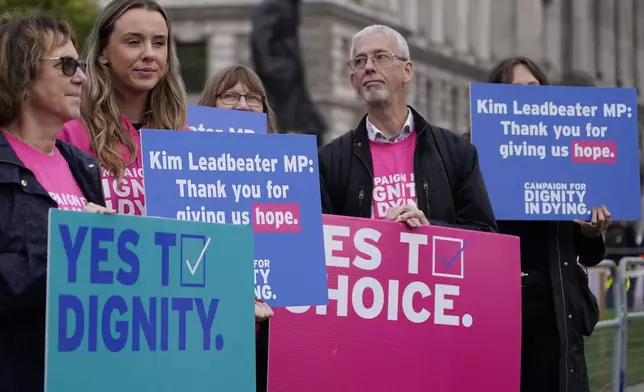 A small demonstration by people advocating assisted dying hold a protest outside the Hoses of Parliament as a bill to legalise assisted dying is to be put before lawmakers in London, England, Wednesday, Oct. 16, 2024. (AP Photo/Alberto Pezzali)