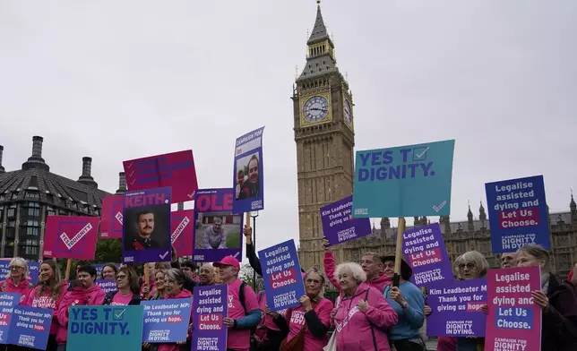 A small demonstration by people advocating assisted dying hold a protest outside the Hoses of Parliament as a bill to legalise assisted dying is to be put before lawmakers in London, England, Wednesday, Oct. 16, 2024. (AP Photo/Alberto Pezzali)