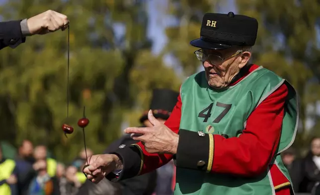 Chelsea pensioner John Riley takes part in the annual World Conker Championships at the Shuckburgh Arms in Southwick, Peterborough, England, Sunday Oct. 13, 2024. (Jacob King/PA via AP)