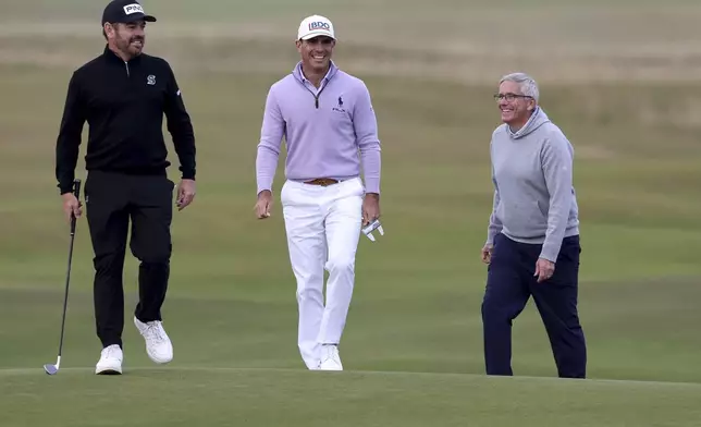 Louis Oosthuizen, left, Billy Horschel and Jay Monahan on the seventeenth green during day three of the Alfred Dunhill Links Championship at the Old Course St. Andrews, Scotland, Saturday Oct. 5, 2024. (Robert Perry/PA via AP)