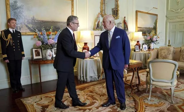 FILE - Britain's King Charles III, right, shakes hands with Keir Starmer where he invited the Labour Party leader to become prime minister and to form a new government, following the landslide general election victory for the Labour Party, in London, Friday, July 5, 2024. (Yui Mok, Pool Photo via AP, File)