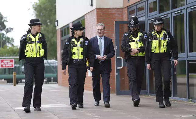 FILE - British Prime Minister Sir Keir Starmer, centre, walks with members of the West Midlands Police Force at Arden Academy in Solihull, West Midlands, England, Thursday Aug. 8, 2024. (Joe Giddens/PA via AP, Pool, FIle)