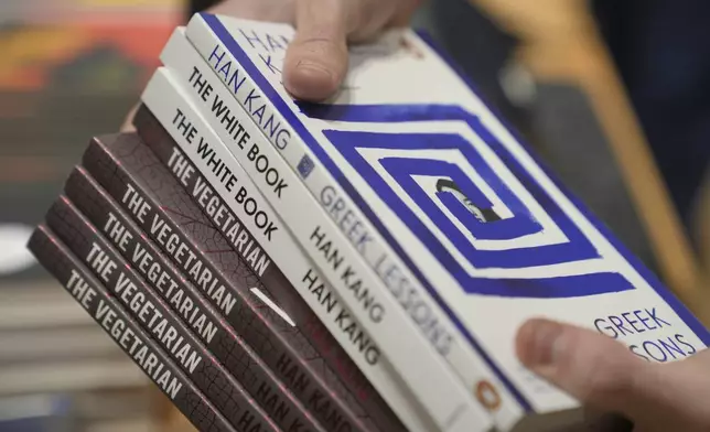 A book store employee handles books by the South Korean writer Han Kang in London, Thursday, Oct. 10, 2024. Kang has been awarded the Nobel Prize for Literature. (AP Photo/Kin Cheung)