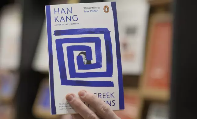 A book store employee holds a book by the South Korean writer Han Kang in London, Thursday, Oct. 10, 2024. Kang has been awarded the Nobel Prize for Literature. (AP Photo/Kin Cheung)