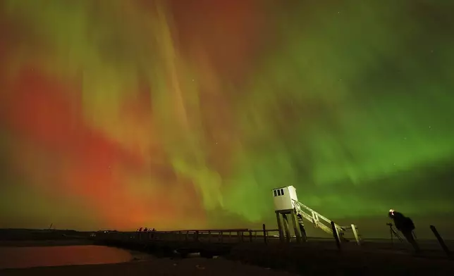 The northern lights, also known as the Aurora Borealis, seen in the skies over the refuge hut on the causeway leading to Holy Island in Northumberland, the North East coast of England, early Friday, Oct. 10, 2024. (Owen Humphreys/PA via AP)