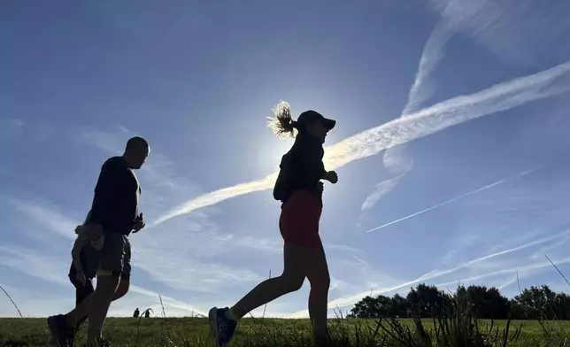 Runners cross Hampstead Heath in north London during a parkrun event on Saturday Sept. 14, 2024. (AP Photo/Lucy Nicholson)