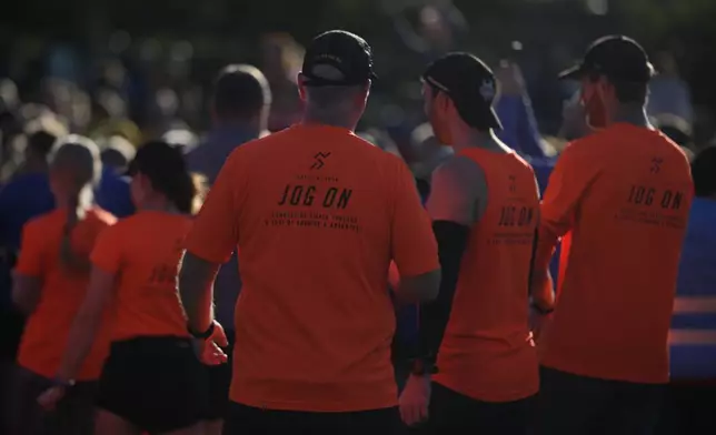 Competitors listen to the briefing before the start of the parkrun event in Bushy Park, southwest London, Saturday, Sept. 28, 2024. (AP Photo/Alastair Grant)