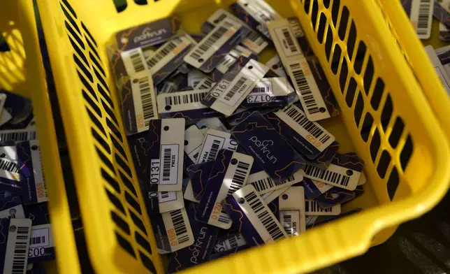 Bar code tags used by competitors are collected at the end of the parkrun event in Bushy Park, southwest London, Saturday, Sept. 28, 2024. (AP Photo/Alastair Grant)