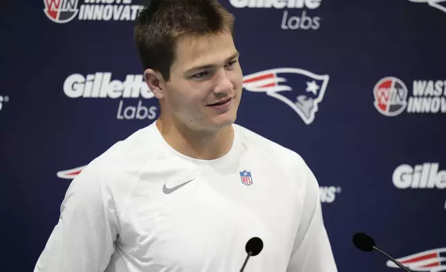 New England Patriots quarterback Drake Maye speaks with media ahead of NFL football practice, Friday, Oct. 18, 2024, in Harrow, England. (AP Photo/Steve Luciano)