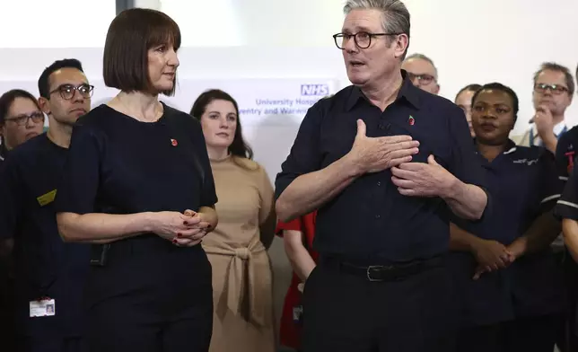 Britain's Prime Minister Keir Starmer and Chancellor Rachel Reeves speak with members of staff, during a visit to University Hospital Coventry and Warwickshire, in Coventry, England, Thursday, Oct. 31, 2024. (AP Photo/Darren Staples, pool)