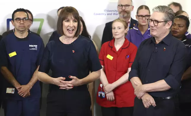 Britain's Prime Minister Keir Starmer and Chancellor Rachel Reeves speak with members of staff, during a visit to University Hospital Coventry and Warwickshire, in Coventry, England, Thursday, Oct. 31, 2024. (AP Photo/Darren Staples, pool)