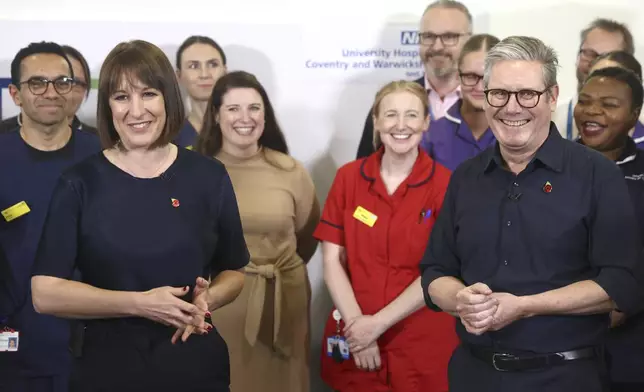 Britain's Prime Minister Keir Starmer and Chancellor Rachel Reeves with members of staff, during a visit to University Hospital Coventry and Warwickshire, in Coventry, England, Thursday, Oct. 31, 2024. (AP Photo/Darren Staples, pool)