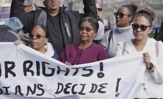 Chagossians Lucy Sagai, center, attends a protest to response the U.K. announcement to agree to hand sovereignty of the long-contested Chagos Islands to Mauritius and against their "Exclusion" from Chagos negotiations, outside the House of Parliament, in London, Monday, Oct. 7, 2024. (AP Photo/Kin Cheung)