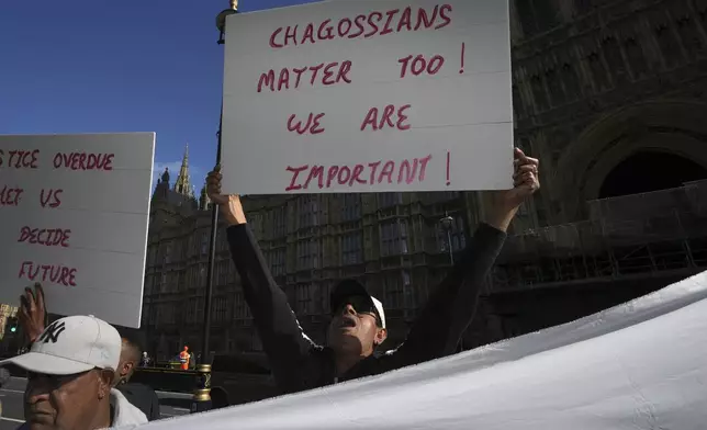 Chagossians attend a protest to response the U.K. announcement to agree to hand sovereignty of the long-contested Chagos Islands to Mauritius and against their "Exclusion" from Chagos negotiations, outside the House of Parliament, in London, Monday, Oct. 7, 2024. (AP Photo/Kin Cheung)