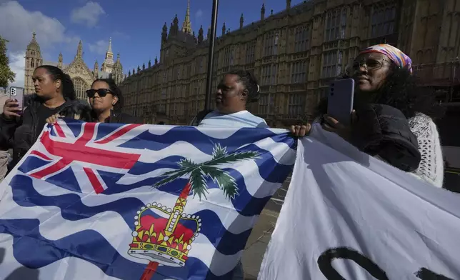 Mary Marjorie Sophie, center, and other Chagossians attend a protest to respond to the U.K. announcement agreeing to hand sovereignty of the long-contested Chagos Islands to Mauritius and against their "Exclusion" from Chagos negotiations, outside the House of Parliament, in London, Monday, Oct. 7, 2024. (AP Photo/Kin Cheung)