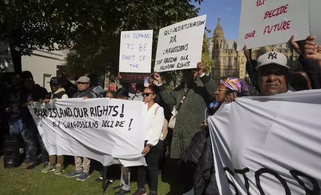 Chagossians attend a protest to respond to the U.K. announcement agreeing to hand sovereignty of the long-contested Chagos Islands to Mauritius and against their "Exclusion" from Chagos negotiations, outside the House of Parliament, in London, Monday, Oct. 7, 2024. (AP Photo/Kin Cheung)