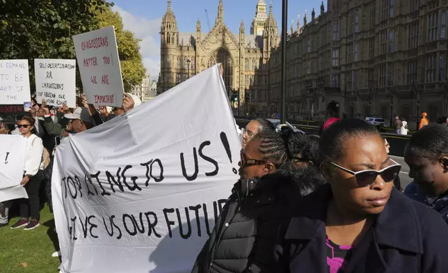 Chagossians attend a protest to response the U.K. announcement to agree to hand sovereignty of the long-contested Chagos Islands to Mauritius and against their "Exclusion" from Chagos negotiations, outside the House of Parliament, in London, Monday, Oct. 7, 2024. (AP Photo/Kin Cheung)