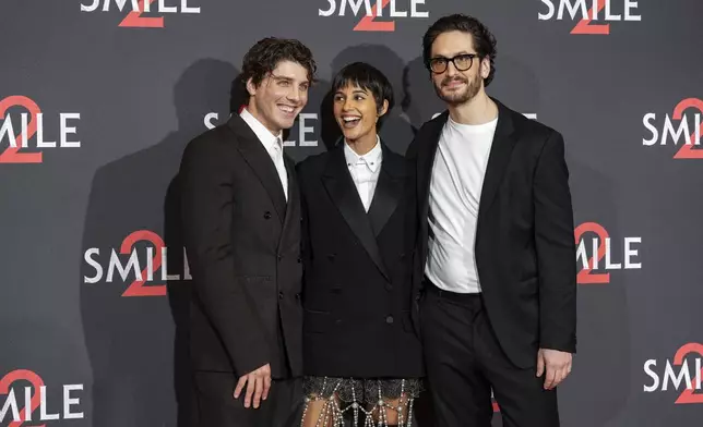 Lukas Gage, from left, Naomi Scott and director Parker Finn pose for photographers upon arrival at the premiere for the film 'Smile 2' on Tuesday, Oct. 8, 2024, in London. (Photo by Scott A Garfitt/Invision/AP)