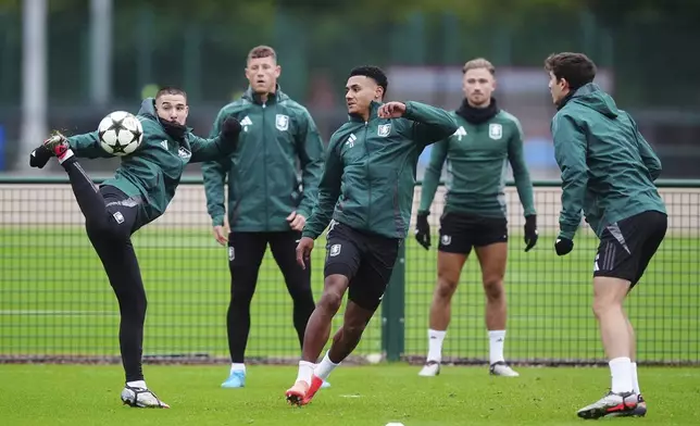 Aston Villa's Emi Buendia, left, and Ollie Watkins, centre, attend a training session at Bodymoor Heath Training Centre, Birmingham, England, Tuesday, Oct. 1, 2024. Aston Villa will face Bayern Munich in the Champions League opening phase soccer match on Wednesday. (Mike Egerton/PA via AP)