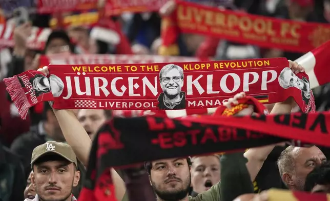 A Liverpool fan holds up a scarf with a picture of former team coach Juergen Klopp, during the English League Cup soccer match between Liverpool and West Ham United at Anfield Stadium, Liverpool, England, Wednesday, Sept. 25, 2024. (AP Photo/Jon Super)