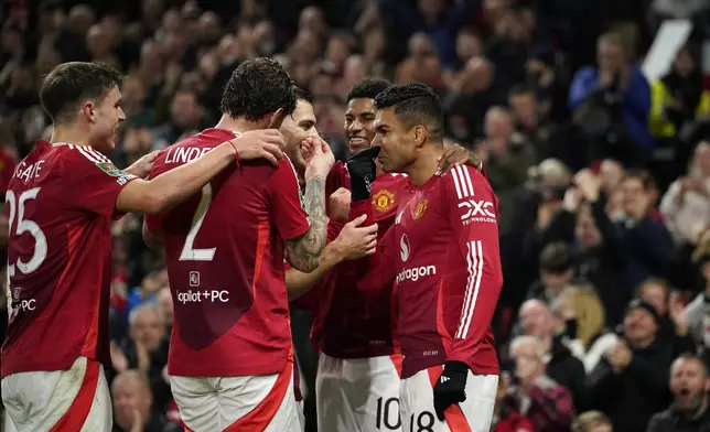 Manchester United's Casemiro, right, celebrates with his teammates after scoring his side's fourth goal during the English League Cup soccer match between Manchester United and Leicester City at the Old Trafford stadium in Manchester, England, Wednesday, Oct. 30, 2024. (AP Photo/Dave Thompson)