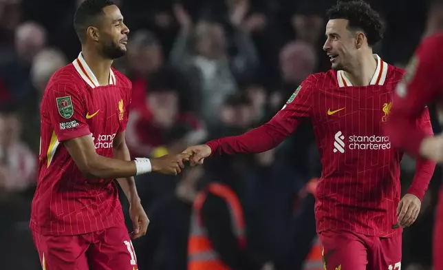 Liverpool's Cody Gakpo, left, celebrates with his teammate Curtis Jones after scoring the first goal during the English League Cup soccer match between Brighton and Liverpool at Falmer Stadium in Brighton, England, Wednesday, Oct. 30, 2024. (AP Photo/Dave Shopland)