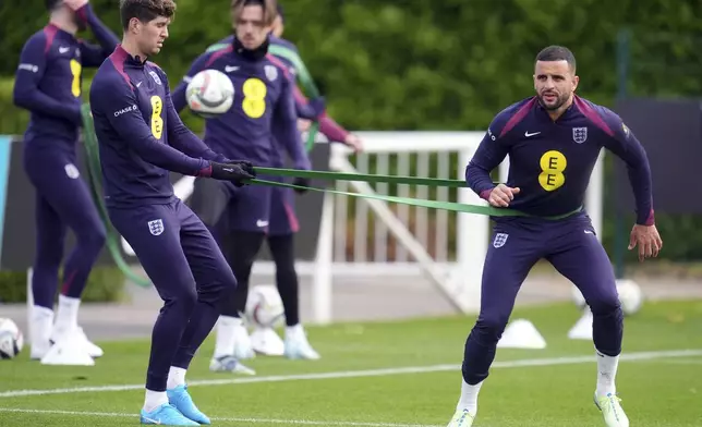 England's John Stones and Kyle Walker, right, during a training session at the Tottenham Hotspur Training Ground, London, Saturday Oct. 12, 2024. (Adam Davy/PA via AP)