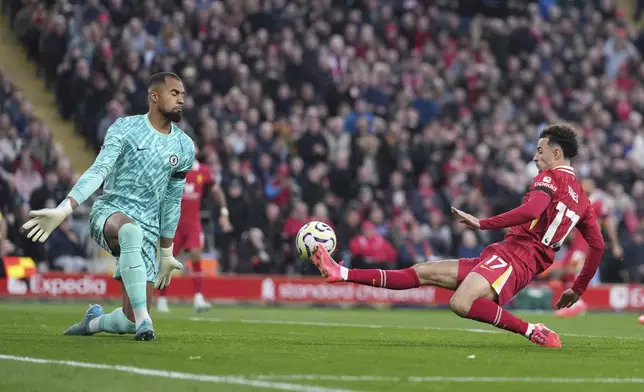 Liverpool's Curtis Jones, right, scores his side's second goal past Chelsea's goalkeeper Robert Sanchez during the English Premier League soccer match between Liverpool and Chelsea at Anfield Stadium, Liverpool, England, Sunday, Oct. 20, 2024. (AP Photo/Jon Super)