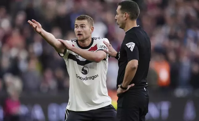 Manchester United's Matthijs de Ligt (left) protests to referee David Coote after he awards a penalty to West Ham United during the English Premier League soccer match between West Ham United and Manchester United at the London Stadium in London, Sunday, Oct. 27, 2024. (John Walton/PA via AP)