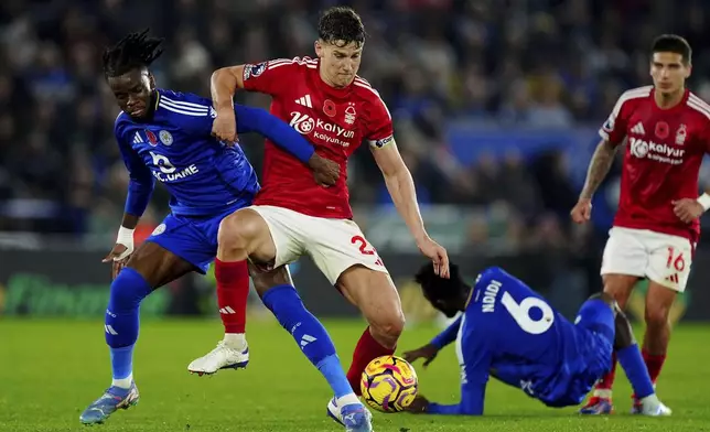 Leicester City's Stephy Mavididi, left, and Nottingham Forest's Ryan Yates, centre, battle for the ball during the Premier League match at the King Power Stadium, in Leicester, England, Friday Oct. 25, 2024. (Mike Egerton/PA via AP)