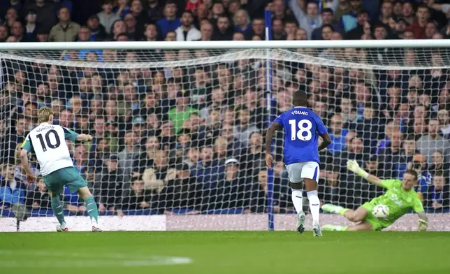 Newcastle United's Anthony Gordon, left, sees his penalty shot saved by Everton goalkeeper Jordan Pickford during the Premier League match at Goodison Park, Liverpool. England, Saturday Oct. 5, 2024. (Peter Byrne/PA via AP)