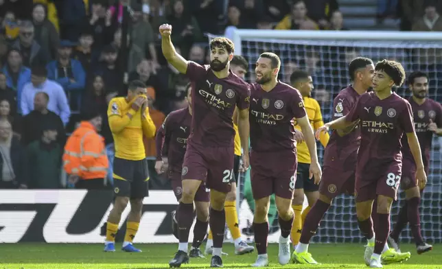 Manchester City's Josko Gvardiol, left, celebrates scoring his side's first goal during the English Premier League soccer match between Wolverhampton Wanderers and Manchester City at the Molineux Stadium in Wolverhampton, England, Sunday, Oct. 20, 2024. (AP Photo/Rui Vieira)