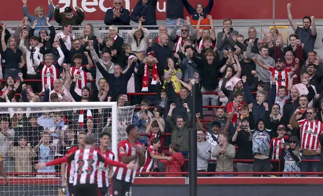 Brentford fans celebrate their side's fourth goal of the game scored by Ethan Pinnock during the Premier League match between Brentford and Wolverhampton at the Gtech Community Stadium, London, Saturday Oct. 5, 2024. (Steven Paston/PA via AP)