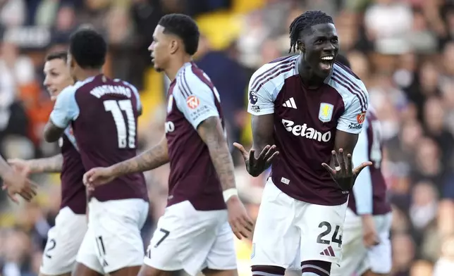 Aston Villa's Amadou Onana celebrates their side's third goal of the game, via an own-goal scored by Fulham's Issa Diop during the English Premier League soccer match between Fulham and Aston Villa at Craven Cottage in London, Saturday Oct. 19, 2024. (John Walton/PA via AP)