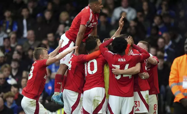 Nottingham Forest's Chris Wood celebrates scoring their side's first goal of the game with team-mates during the English Premier League soccer match between Chelsea and Nottingham Forest at Stamford Bridge in London, Sunday Oct. 6, 2024. (Bradley Collyer/PA via AP)