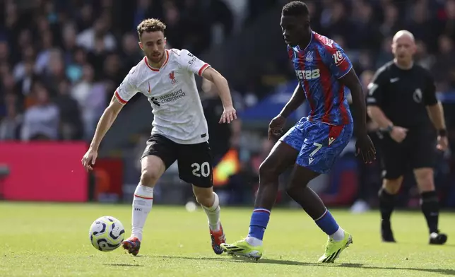 Liverpool's Diogo Jota, left, and Crystal Palace's Ismaila Sarr challenge for the ball the English Premier League soccer match between Crystal Palace and Liverpool at Selhurst Park in London, Saturday, Oct. 5, 2024.(AP Photo/Ian Walton)