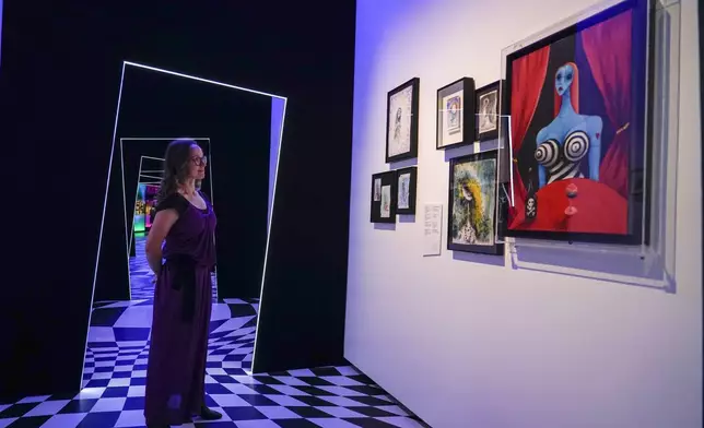 A member of staff poses at The World of Tim Burton exhibition at the Design Museum, in London, Monday, Oct. 21, 2024. The major exhibition sees Tim Burton's personal archives on display for the first time, featuring 600 items from his nearly fifty years long career. (AP Photo/Alberto Pezzali)