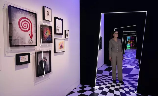 A member of staff poses at The World of Tim Burton exhibition at the Design Museum, in London, Monday, Oct. 21, 2024. The major exhibition sees Tim Burton's personal archives on display for the first time, featuring 600 items from his nearly fifty years long career. (AP Photo/Alberto Pezzali)