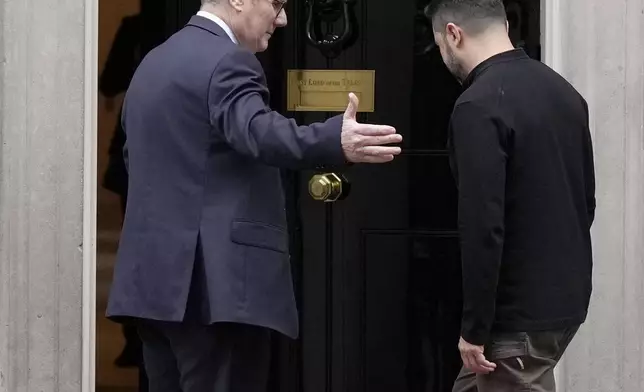 Britain's Prime Minister Keir Starmer welcomes Ukrainian President Volodymyr Zelenskyy to 10 Downing Street as Larry the cat, Chief Mouser to the Cabinet Office, steps out in London, Thursday, Oct. 10, 2024.(AP Photo/Alastair Grant)