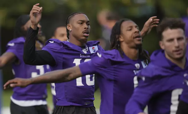 Minnesota Vikings wide receiver Justin Jefferson (18), second left, works out during NFL football practice at The Grove in Watford, England, Friday, Oct. 4, 2024. (AP Photo/Kin Cheung)