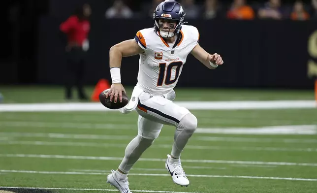 Denver Broncos quarterback Bo Nix scrambles up field during the first half of an NFL football game against the New Orleans Saints, Thursday, Oct. 17, 2024, in New Orleans. (AP Photo/Butch Dill)