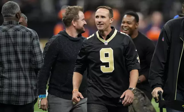 Former New Orleans Saints quarterback Drew Brews walks on the field before an NFL football game between the Saints and the Denver Broncos, Thursday, Oct. 17, 2024, in New Orleans. (AP Photo/Gerald Herbert)