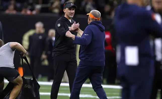 New Orleans Saints head coach Dennis Allen, left, greets Denver Broncos head coach Sean Payton before an NFL football game, Thursday, Oct. 17, 2024, in New Orleans. (AP Photo/Butch Dill)