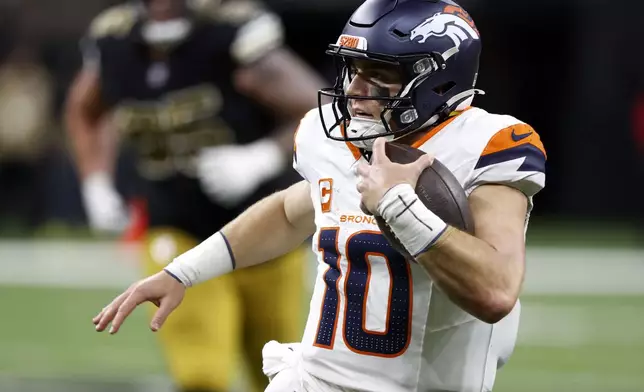 Denver Broncos quarterback Bo Nix scrambles up field during the second half of an NFL football game against the New Orleans Saints, Thursday, Oct. 17, 2024, in New Orleans. (AP Photo/Butch Dill)