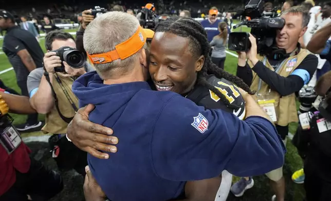 New Orleans Saints running back Alvin Kamara (41) hugs Denver Broncos head coach Sean Payton after an NFL football game, Thursday, Oct. 17, 2024, in New Orleans. The Broncos won 33-10. (AP Photo/Gerald Herbert)