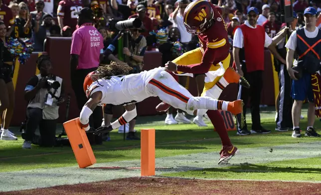 Washington Commanders quarterback Jayden Daniels, right, is knocked out of bounds by Cleveland Browns cornerback Mike Ford Jr., left, during the second half of an NFL football game in Landover, Md., Sunday, Oct. 6, 2024. (AP Photo/Nick Wass)