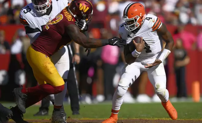 Cleveland Browns quarterback Deshaun Watson (4) break away from Washington Commanders defensive end Dorance Armstrong (92) during the second half of an NFL football game in Landover, Md., Sunday, Oct. 6, 2024. (AP Photo/Nick Wass)